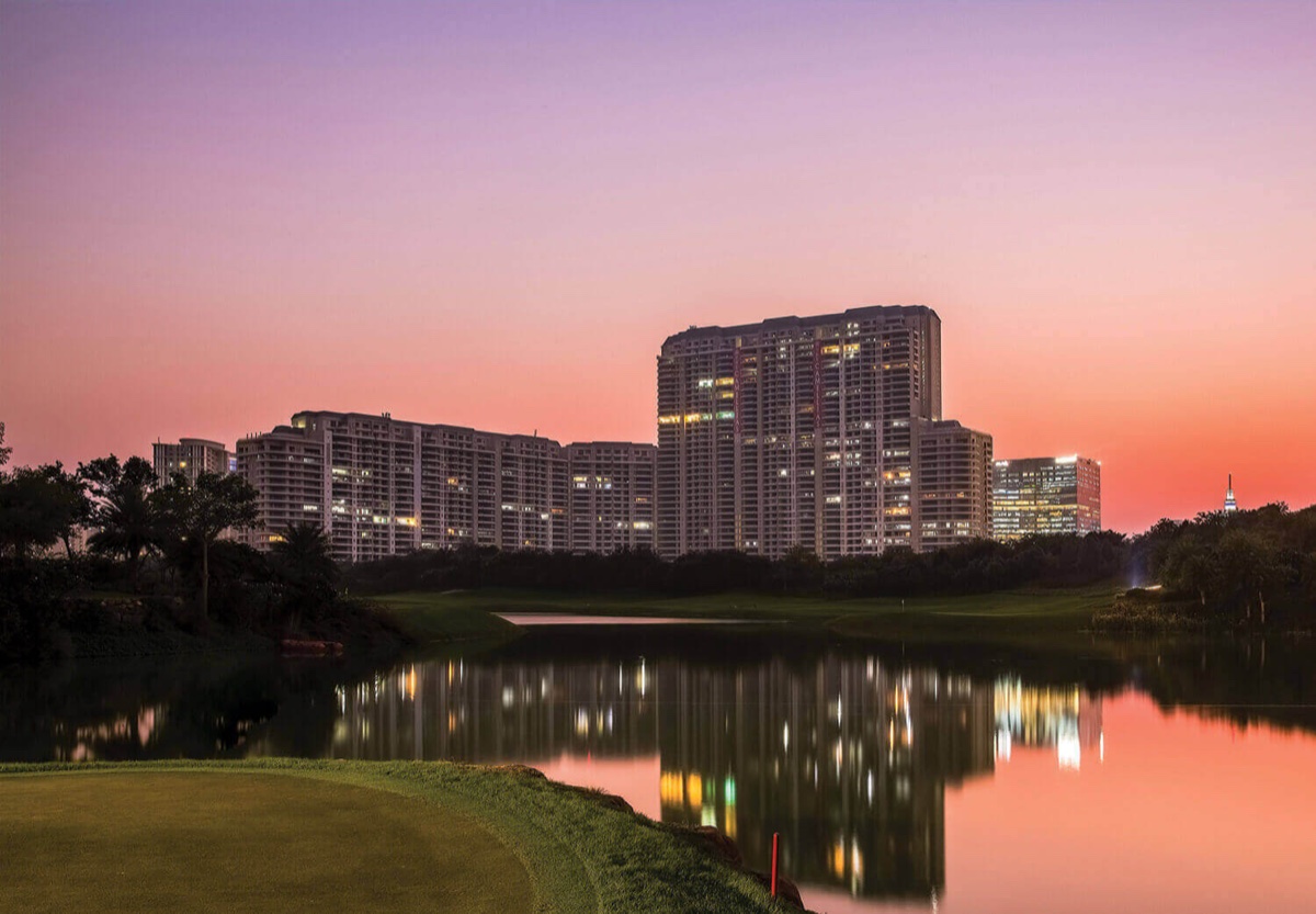 The Camellias towers across the golf-course lake at sunset (photograph)